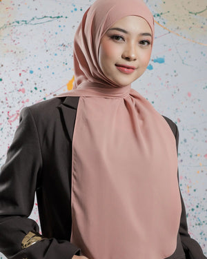 Woman wearing a pink hijab and black outfit against a colorful abstract background