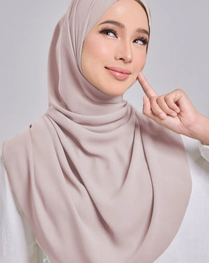 Woman wearing a beige hijab with a neutral background