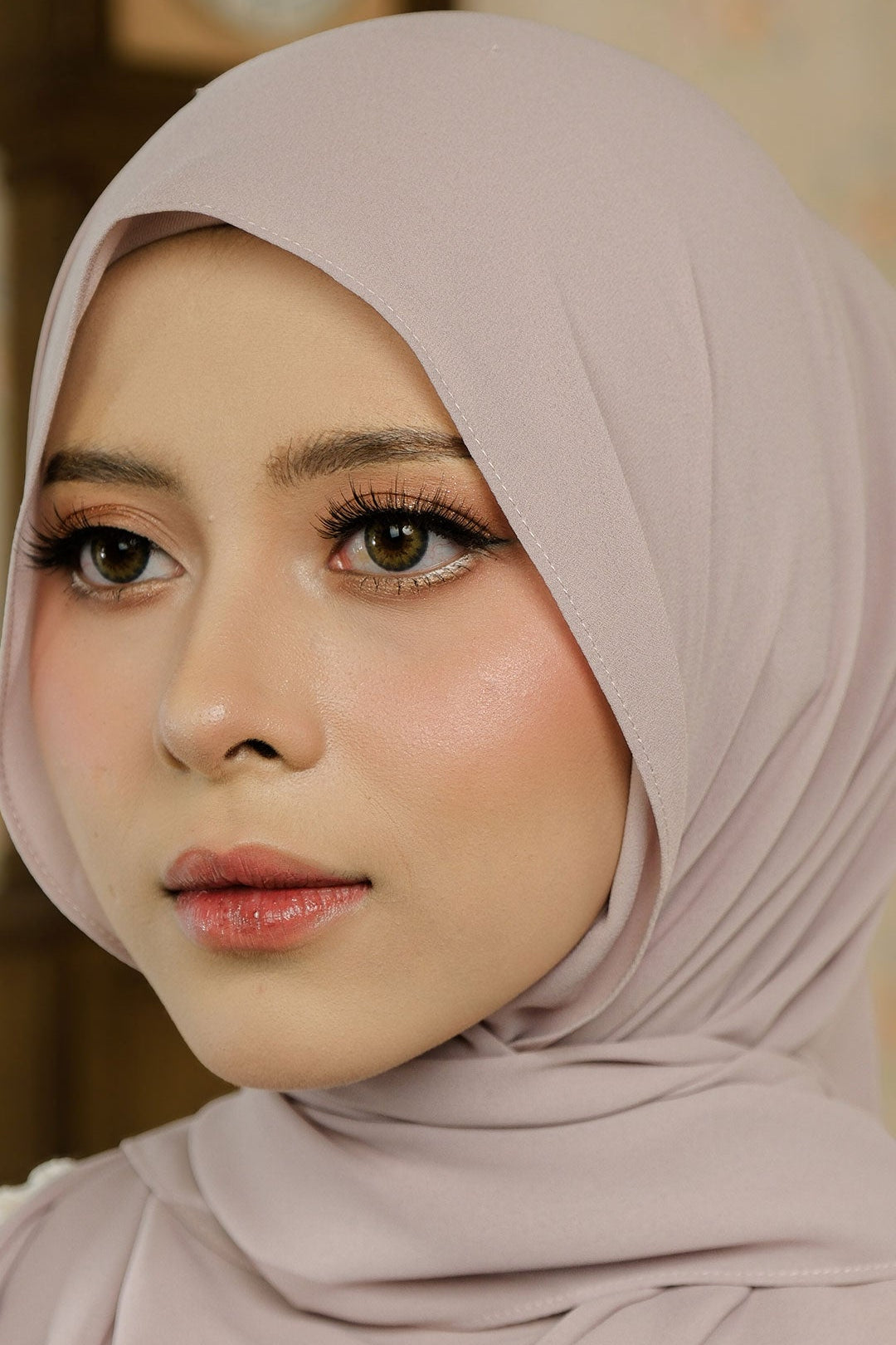 Woman wearing a light pink hijab with a blurred background