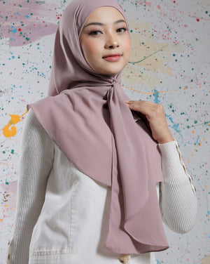 Woman wearing a light pink hijab against a colorful abstract background