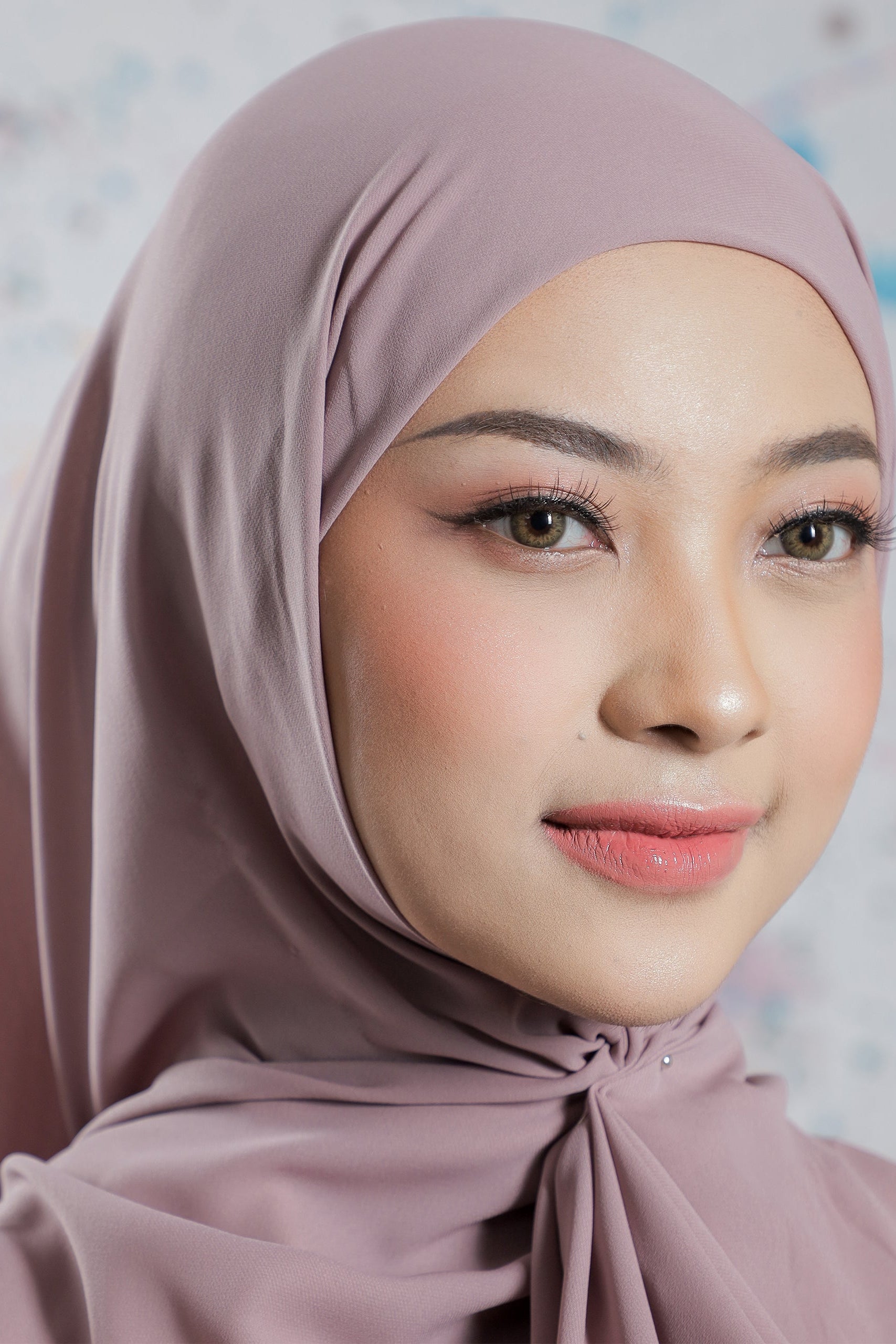 Woman wearing a light brown hijab with a blurred background