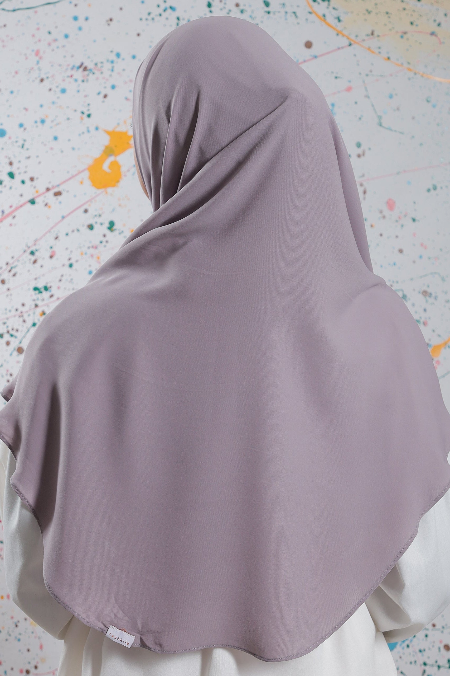 Purple hijab on a chair with a multicolored speckled background