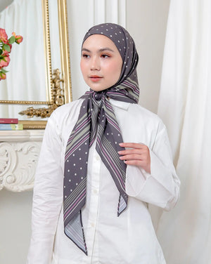 Woman wearing a patterned scarf in a room with decorative elements