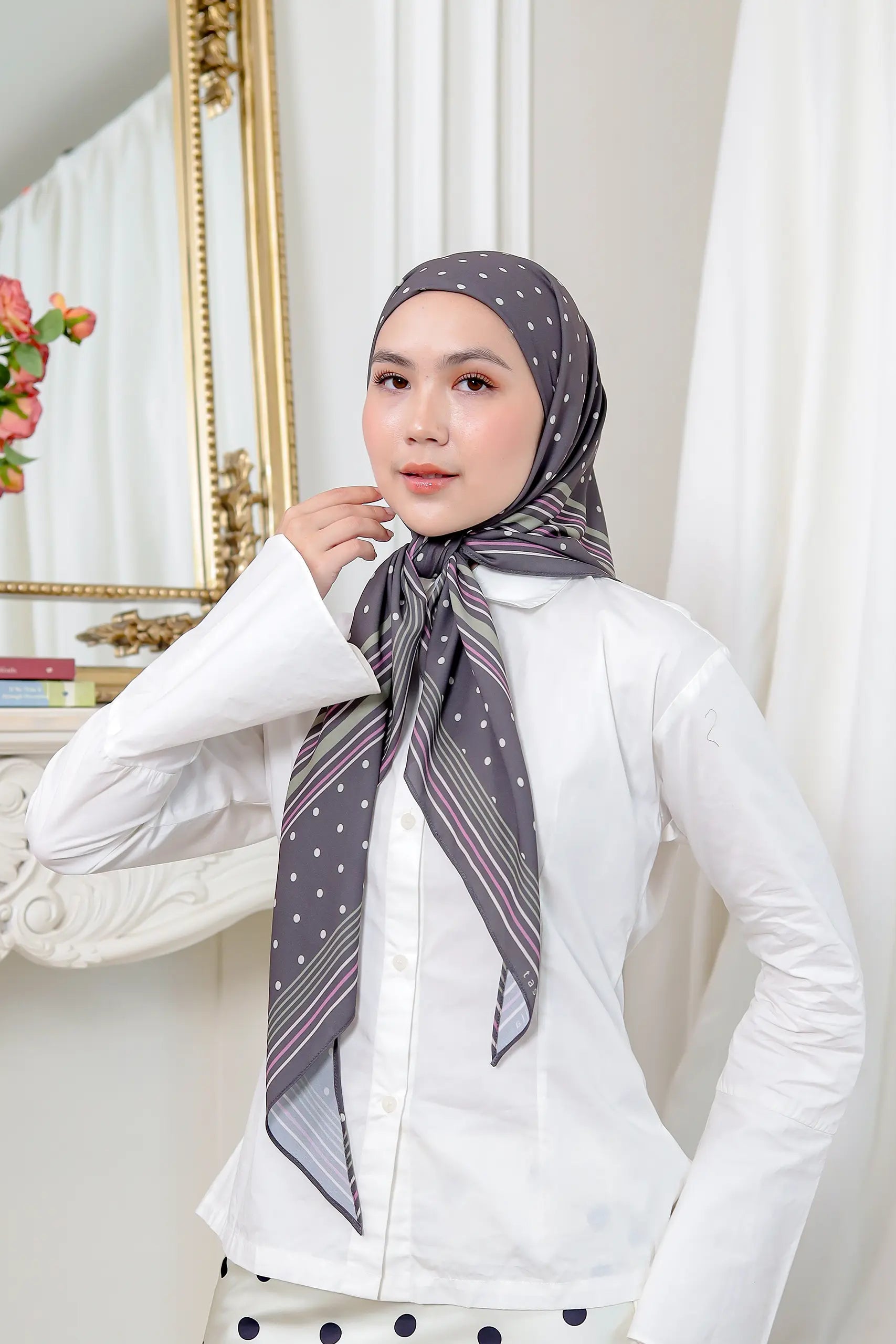 Woman wearing a patterned scarf in a room with decorative elements