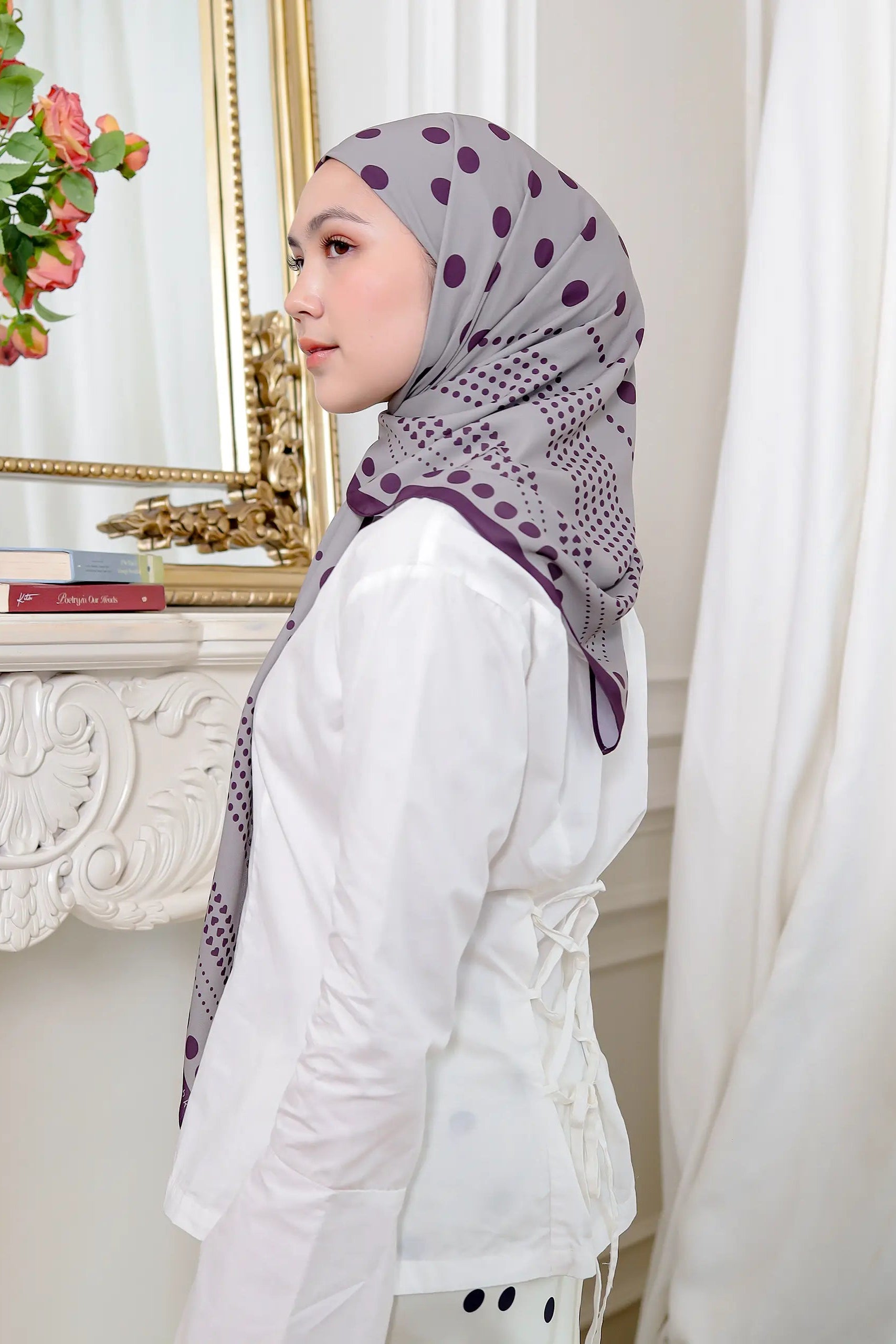 Woman wearing a patterned hijab in a room with decorative elements