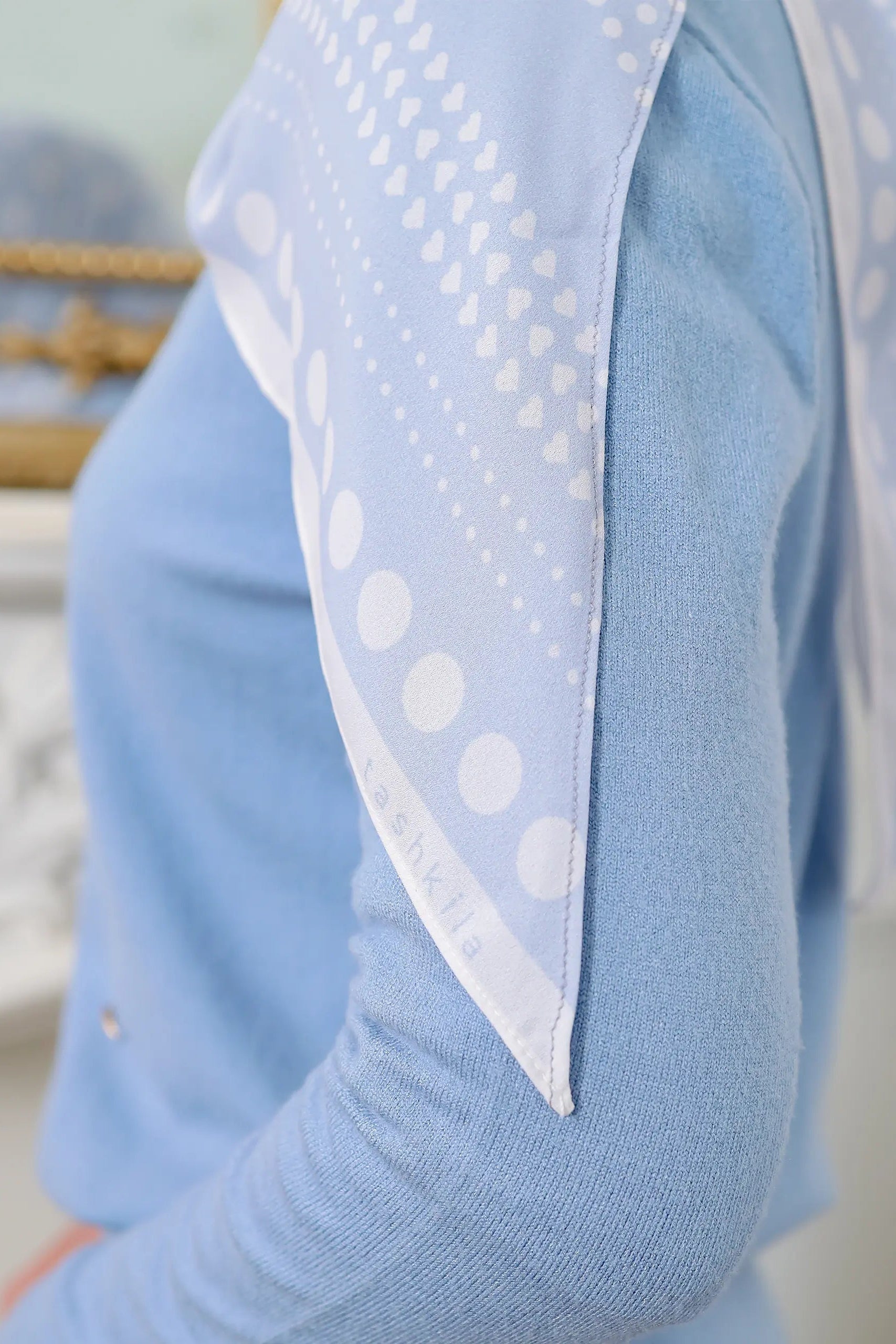 Light blue sweater with a white polka dot scarf